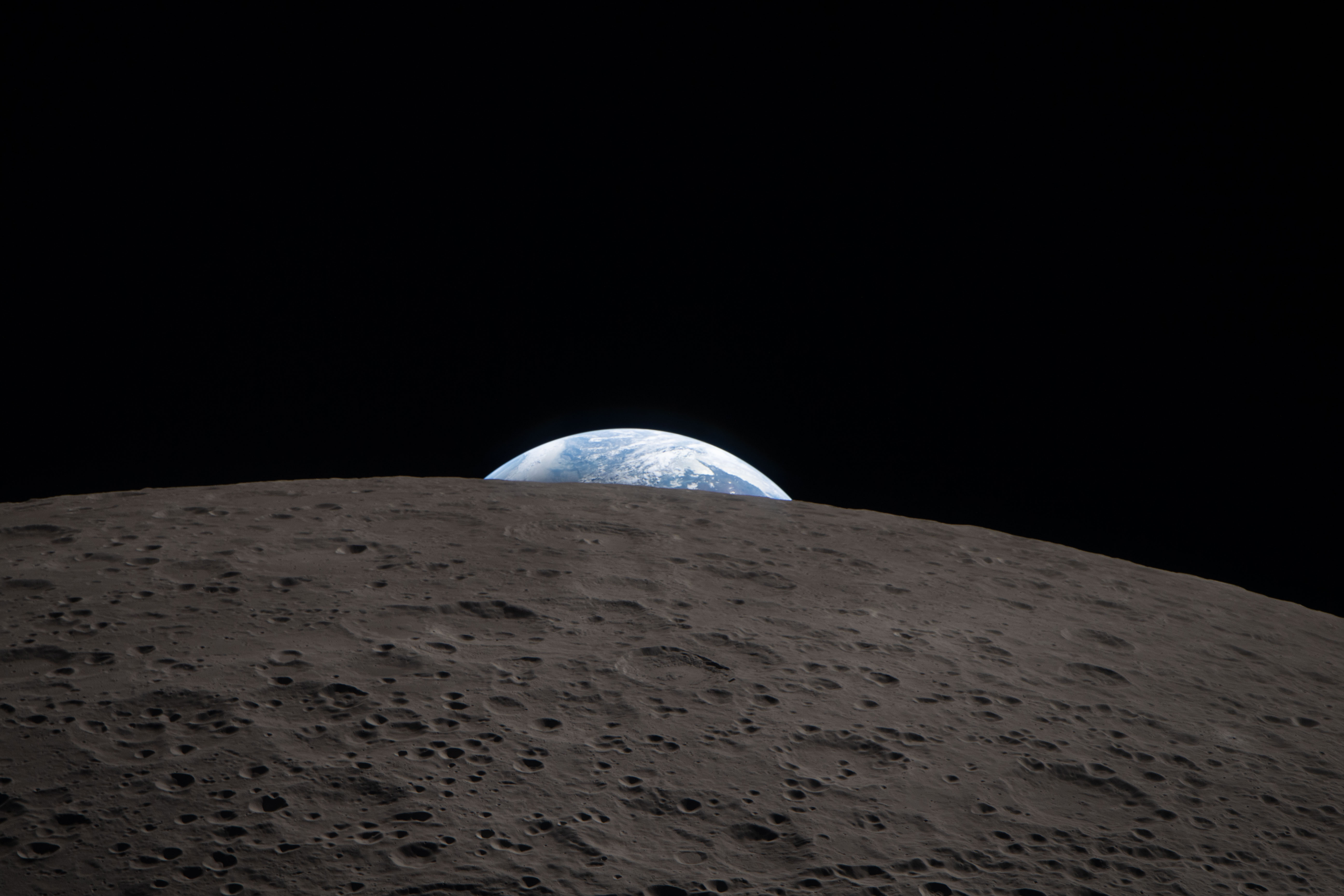 Echoing the iconic Apollo 8 Earthrise from 1968, this image shows Earth rising above the lunar surface as captured by the Artemis II crew from the Orion spacecraft.