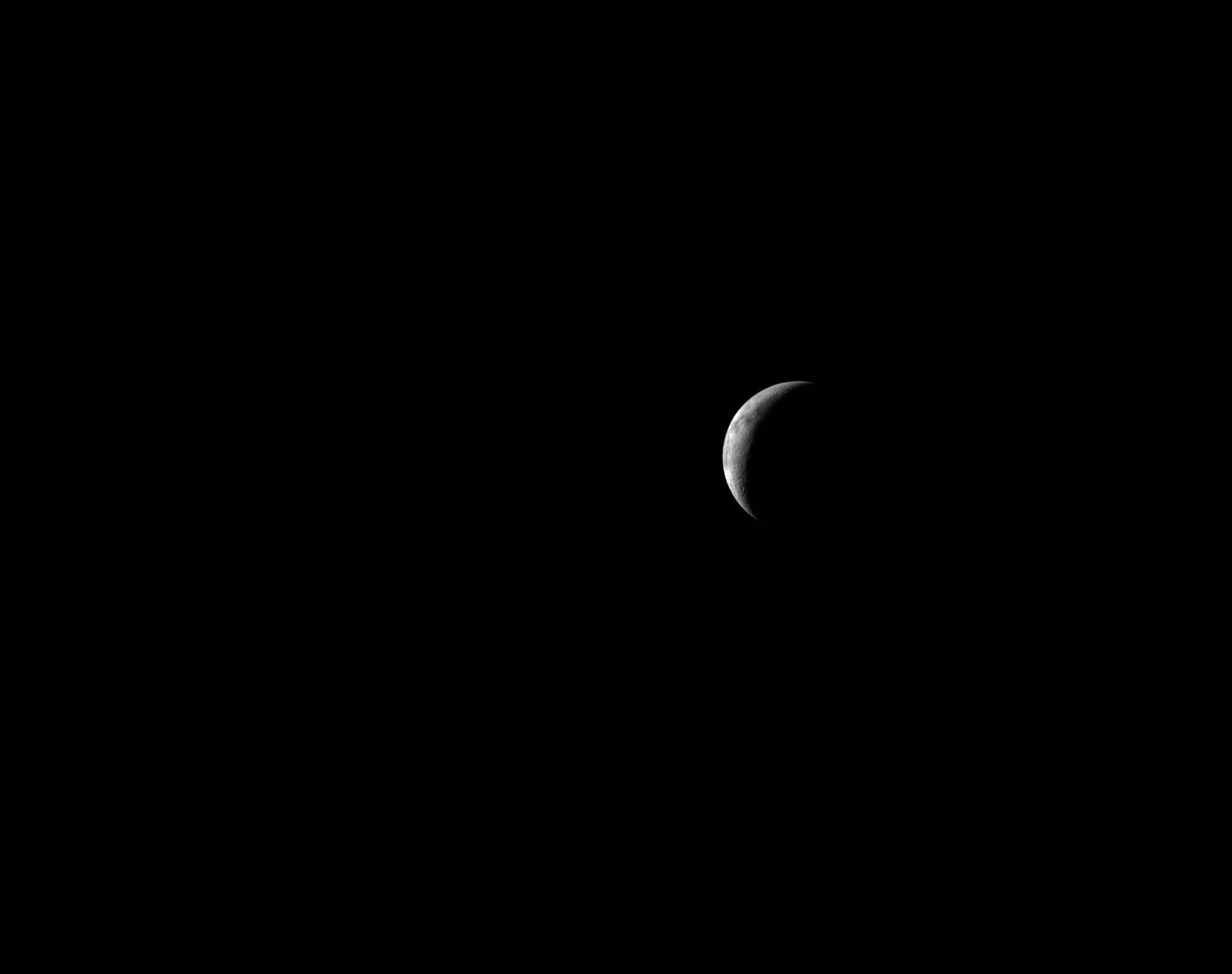 A thin lunar crescent captured by the Artemis II crew as they traveled back to Earth on April 8, 2026 — the Moon they just left, receding into the distance.