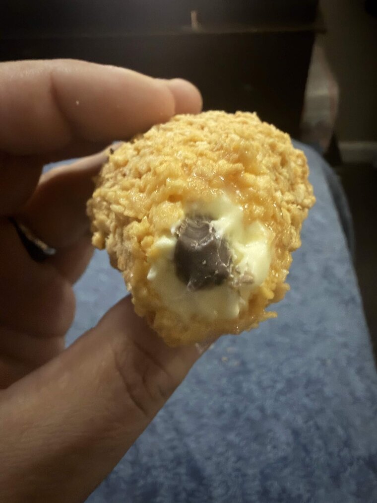 A bitten Fried Chicken Ice Cream showing the vanilla ice cream interior and chocolate 'bone' center