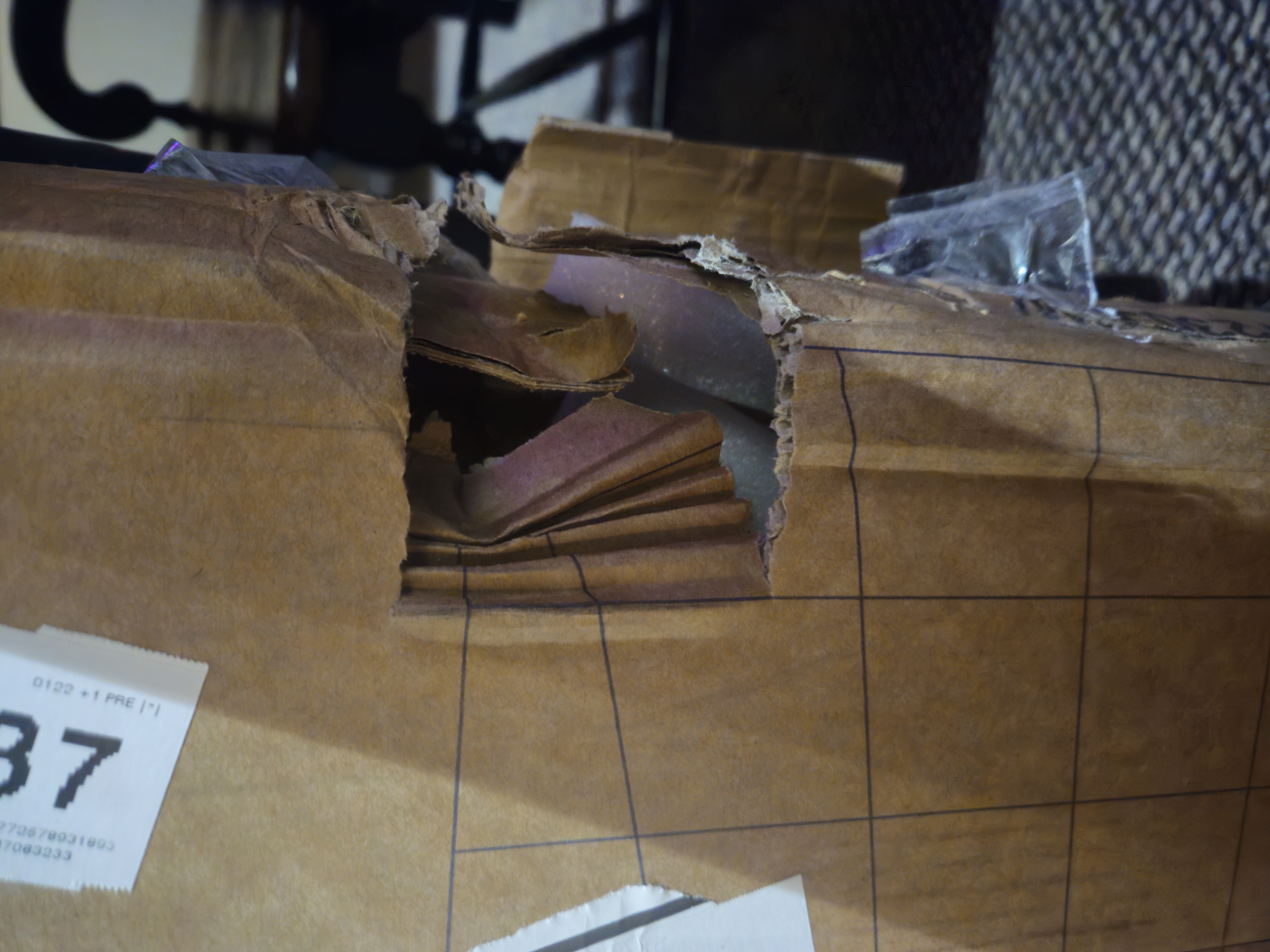 Damaged shipping box showing external impact damage