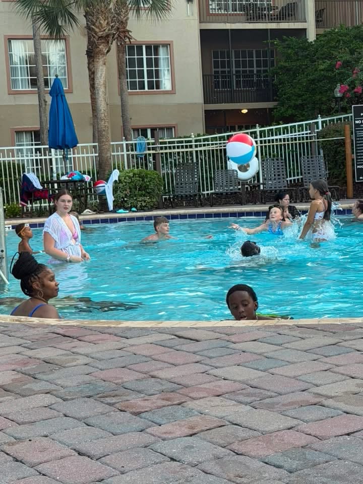 Kids splash and play with a beach ball in the resort pool