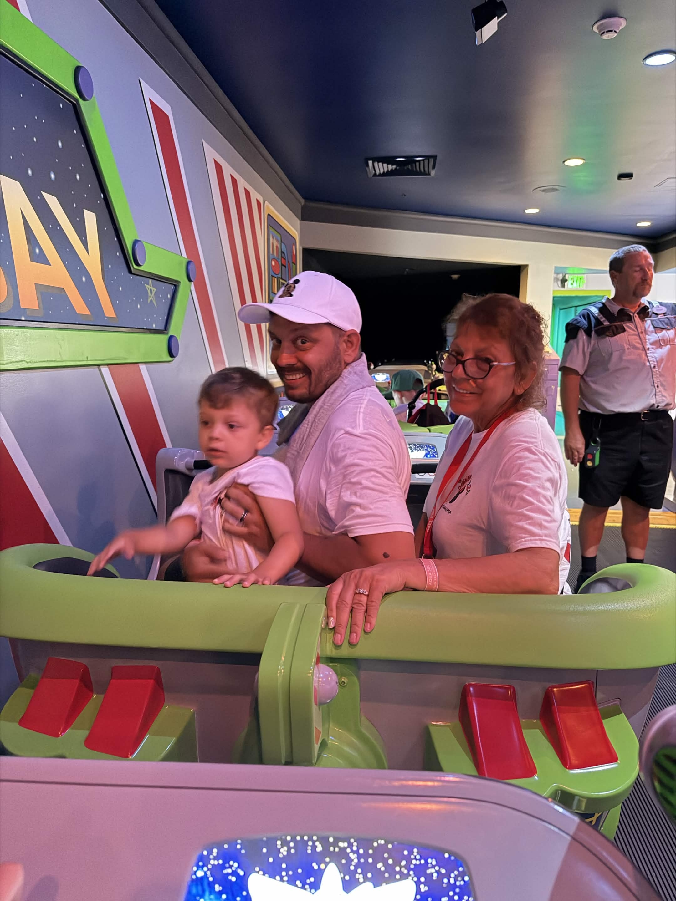 Family in Buzz Lightyear ride vehicle with a Cast Member nearby