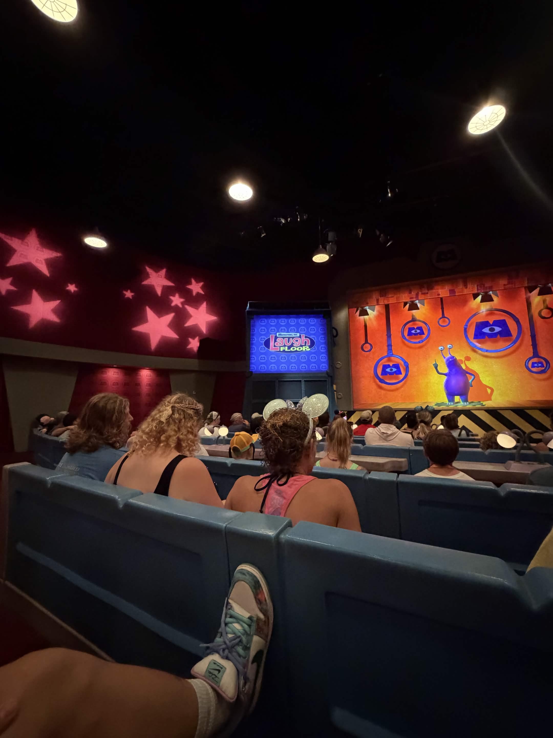 Laugh Floor stage with pink star projections and a monster character on screen