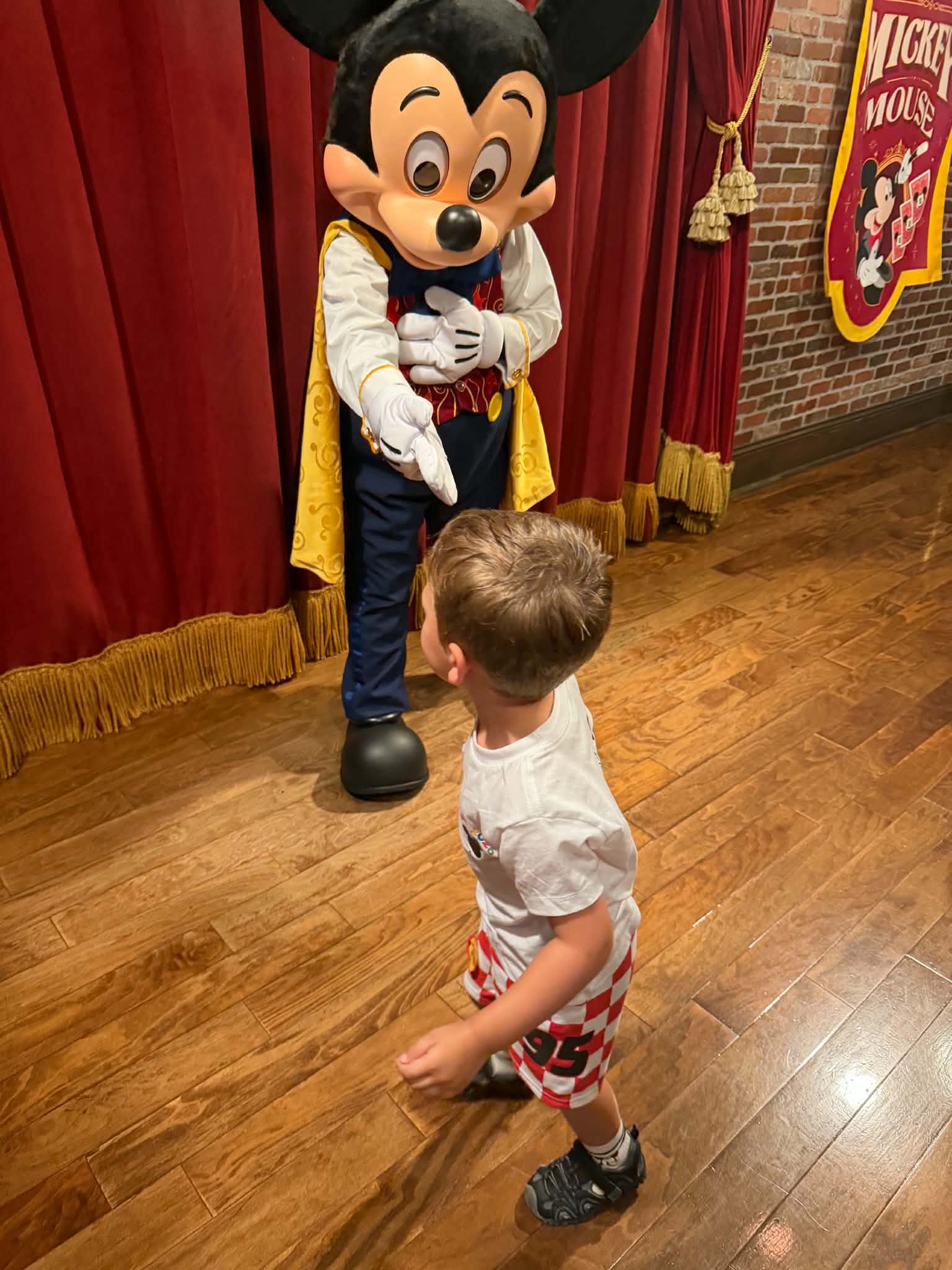 Young boy walking up to meet Mickey Mouse in his meet-and-greet room