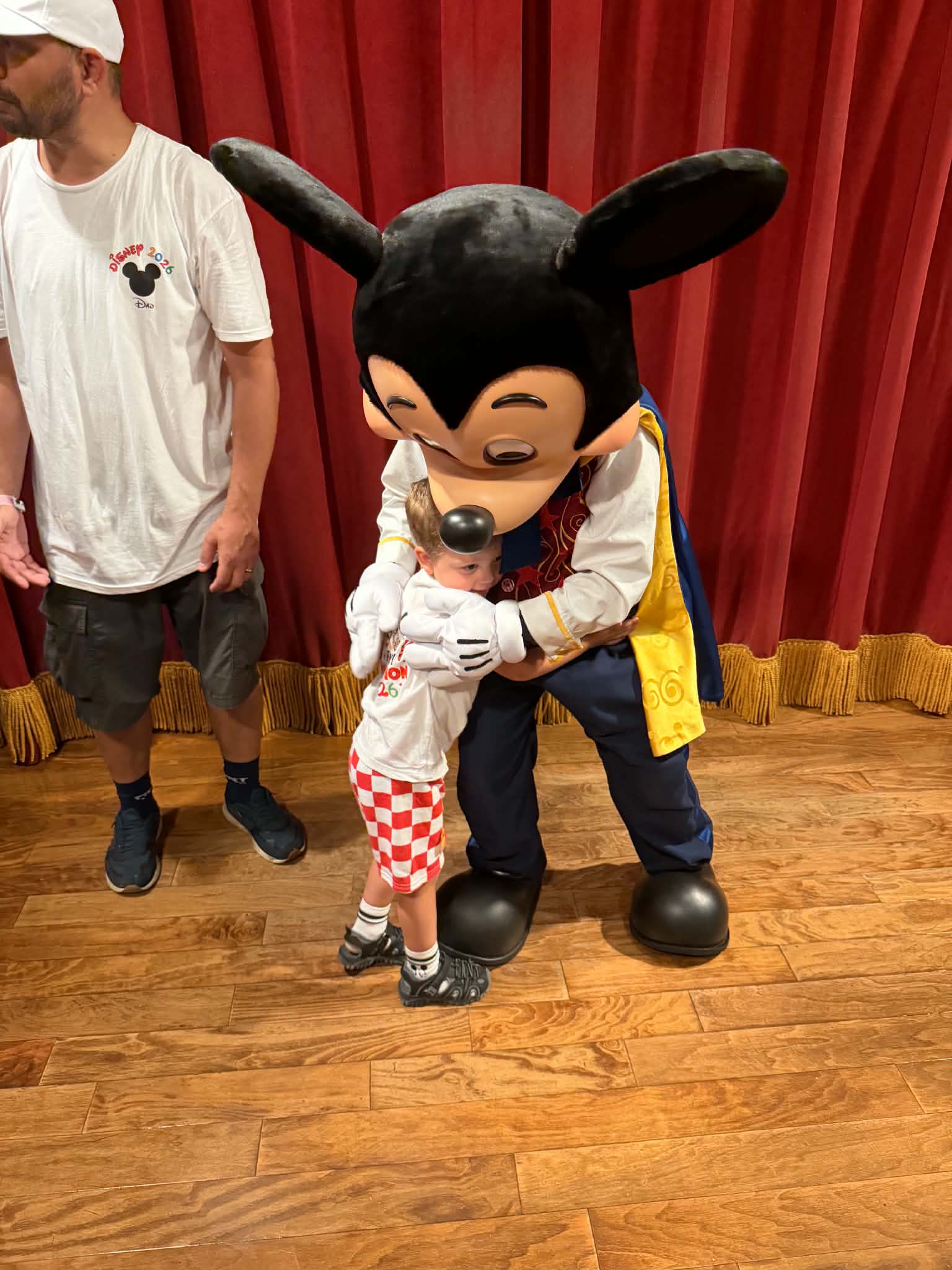 Mickey Mouse giving a young boy a big hug during meet and greet