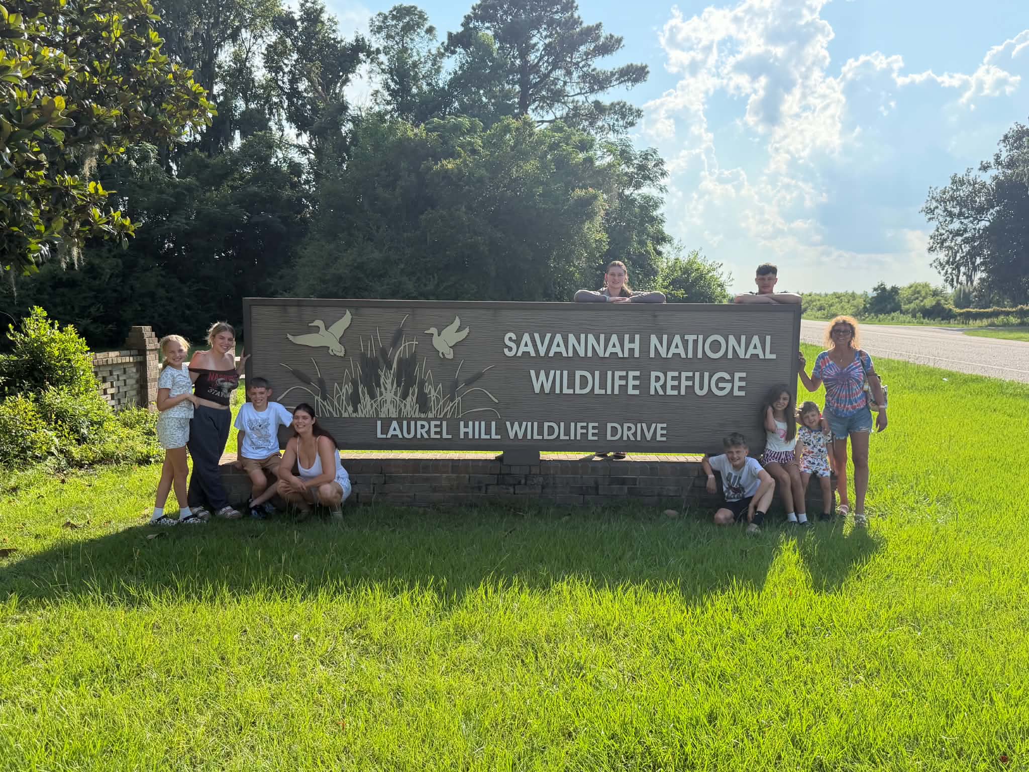 Bright group portrait at the Savannah National Wildlife Refuge sign